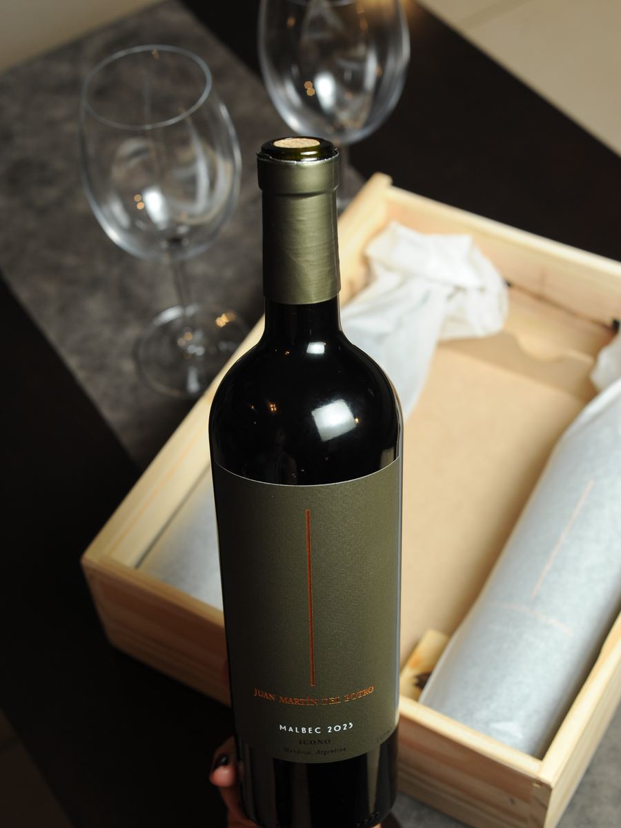 Botella del Malbec 2023 Ícono en su caja de madera, con dos copas