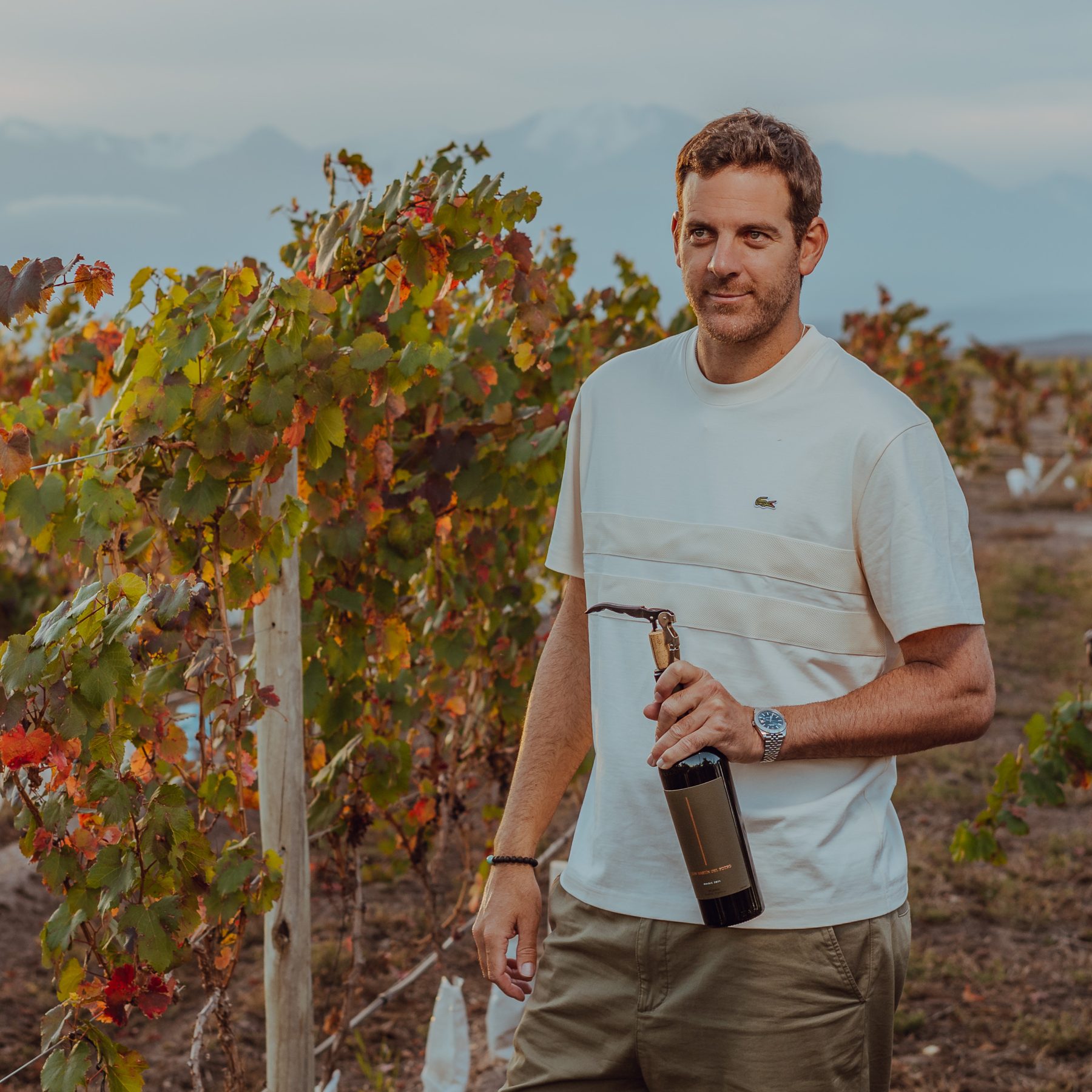 Juan Martín Del Potro en el viñedo de Mendoza, con la botella y un descorchador